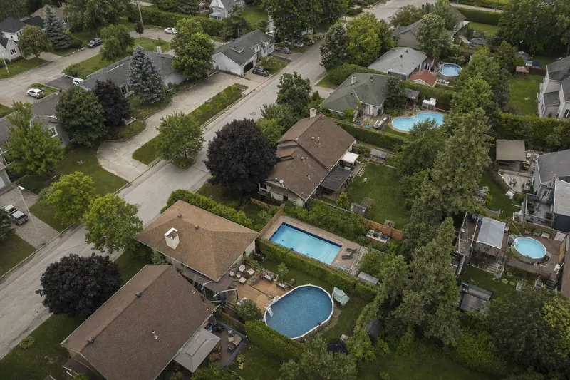 Un quartier de banlieue vu du ciel, avec des piscines, des clôtures et des terrasses